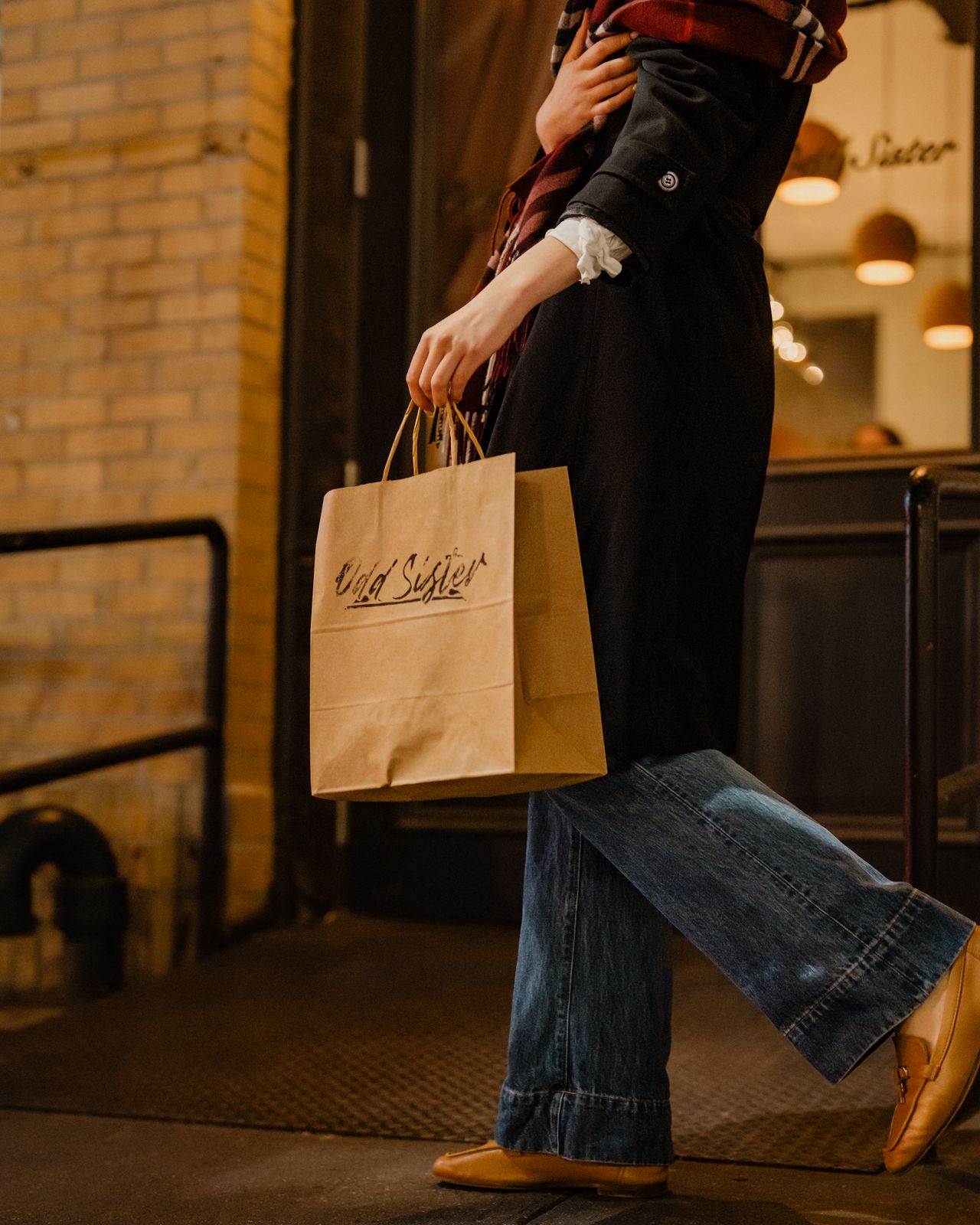 A guest leaving Odd Sister with a hand-lettered takeaway bag